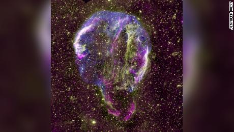 Pokazano radiowy (fioletowy), UV (żółty) i rentgenowski (niebieski) obraz pozostałości supernowej pierścienia Łabędzia w Drodze Mlecznej. 