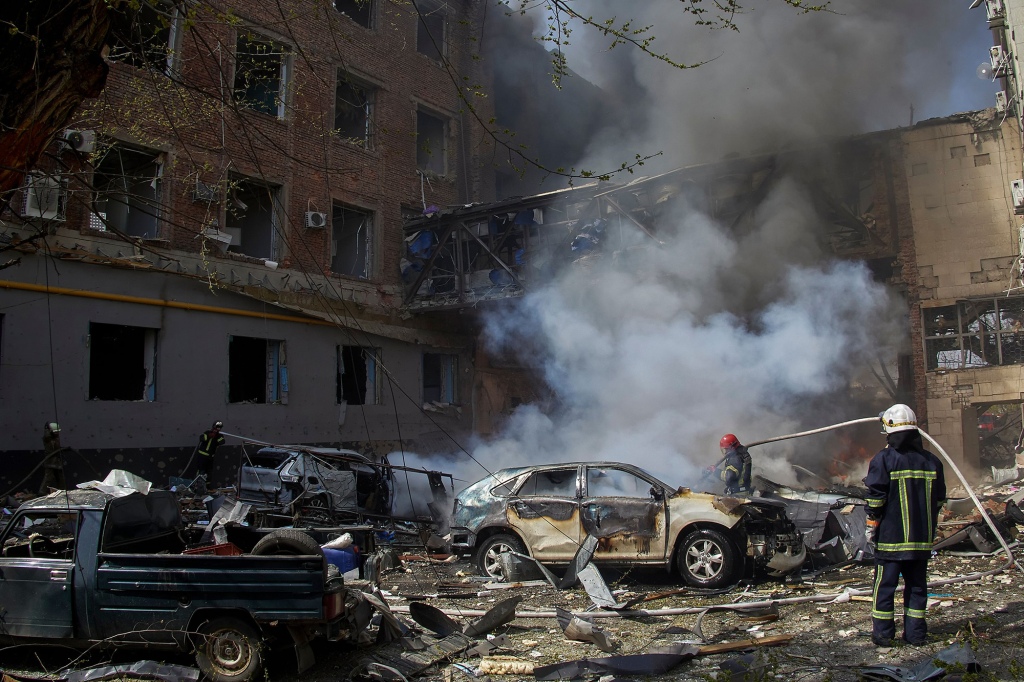 Ukraińscy strażacy pracują w dzielnicy mieszkalnej zniszczonej po rosyjskich bombardowaniach.