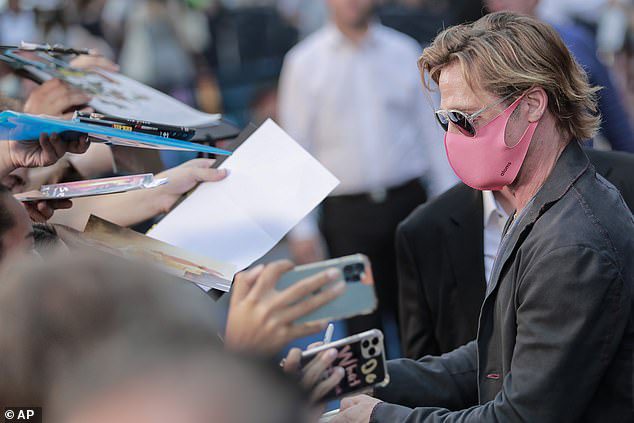 Hołd dla fanów: Brad nosił różową osłonę twarzy, aby chronić siebie i innych przed koronawirusem, podpisując autografy dla fanów podczas imprezy