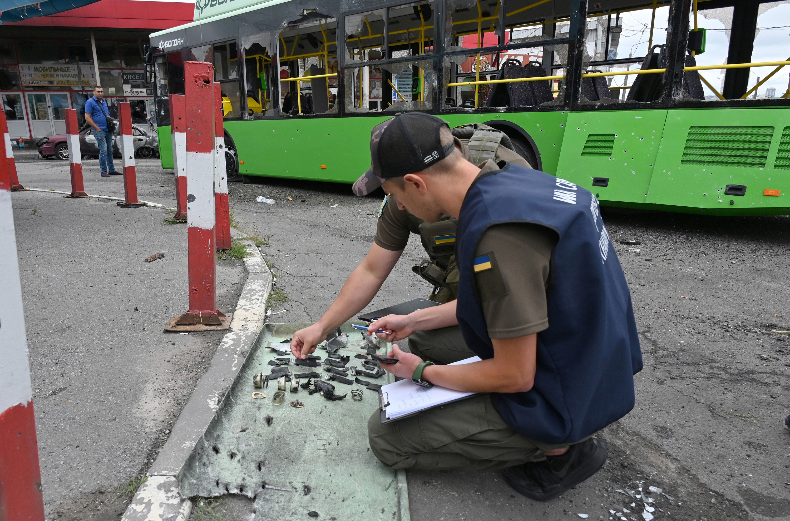 Ukraińskie władze odbierają odłamki po rosyjskim ataku rakietowym w Charkowie na Ukrainie, czwartek.