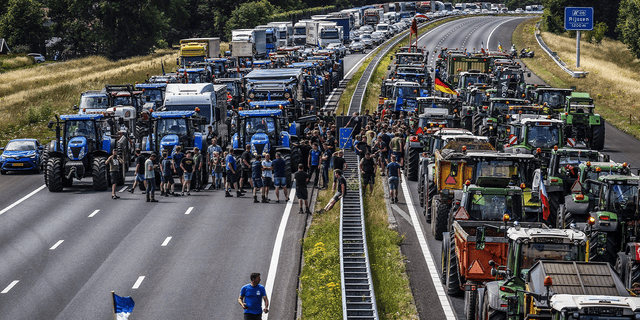 Rolnicy gromadzą się swoimi samochodami obok znaku granicznego między Niemcami a Holandią podczas protestu na autostradzie A1, niedaleko Riesen, 29 czerwca 2022 r., przeciwko planom holenderskiego rządu dotyczącym azotu.  - Netherlands OUT (fot. Vincent Jannink/ANP/AFP) / Netherlands OUT (fot. VINCENT JANNINK/ANP/AFP via Getty Images)