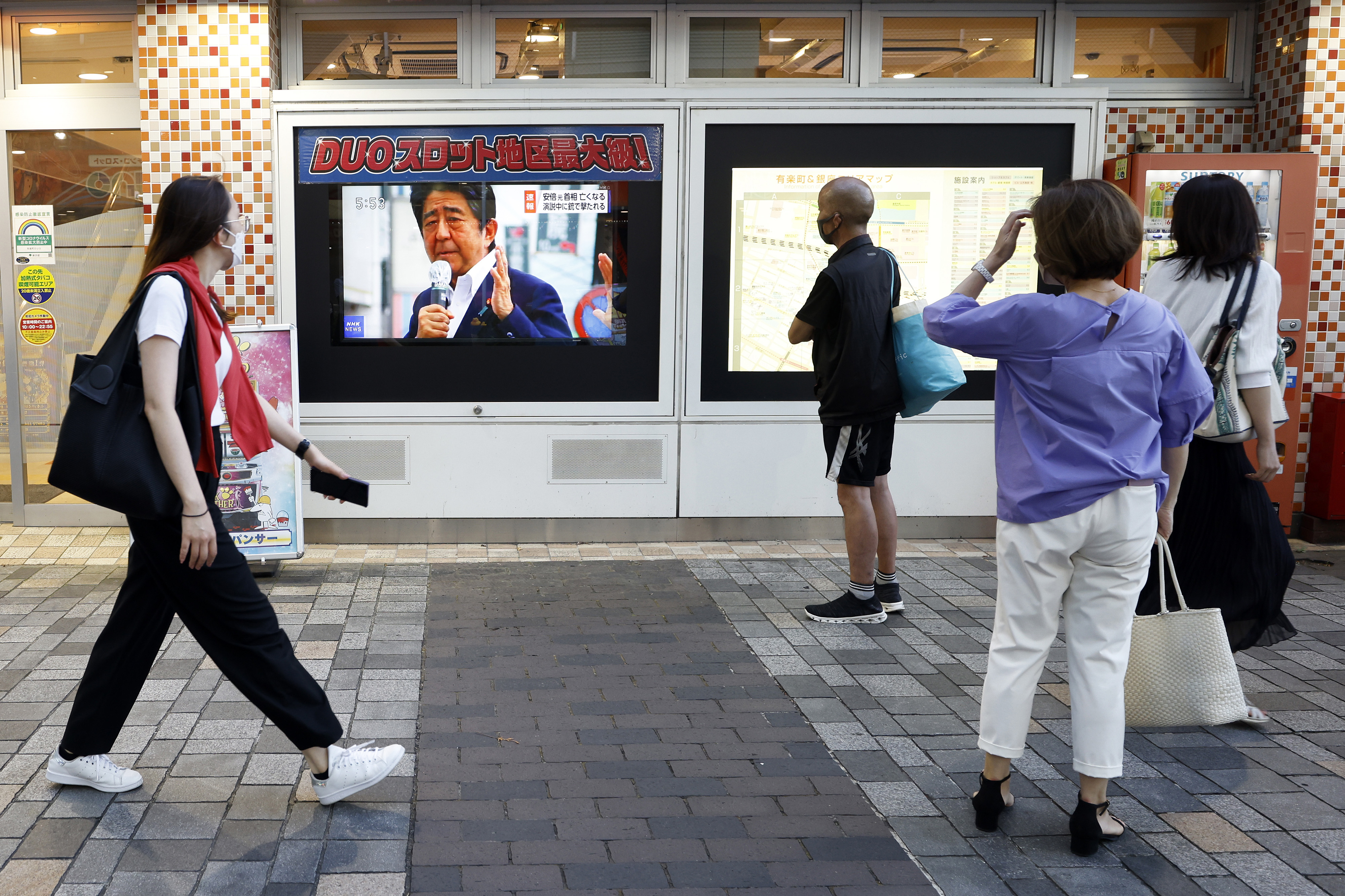 Przechodnie oglądają biuletyn informacyjny o zabójstwie byłego japońskiego premiera Shinzo Abe w Tokio, 8 lipca. 