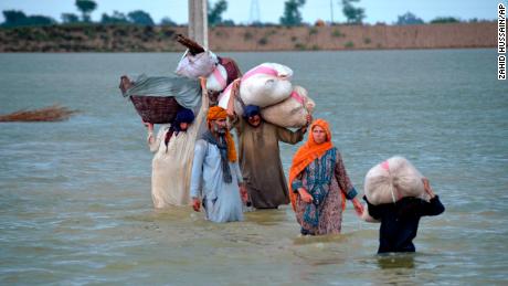 Przesiedlona rodzina brodzi w zalanym obszarze w Jafarabadzie, dystrykcie południowo-zachodniej prowincji Beludżystan w Pakistanie, 24 sierpnia.