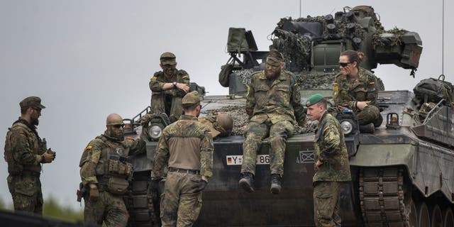 Żołnierze armii niemieckiej z batalionu NATO Enhanced Front Presence czekają na przyjęcie niemieckiego kanclerza Olafa Schulza przed przybyciem na poligon treningowy w Paprad, 38 mil na północ od stolicy, Wilna na Litwie, wtorek, 7 czerwca 2022 r. 