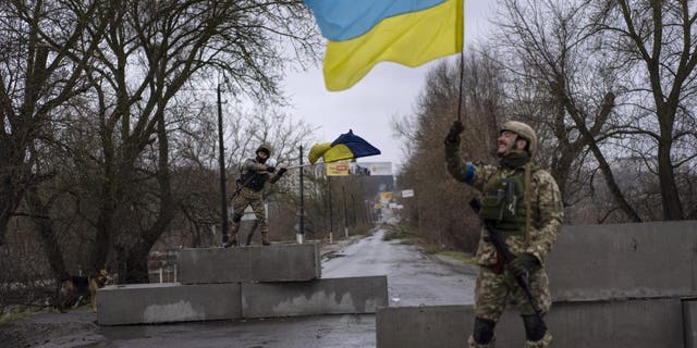 Żołnierze ukraińscy świętują na punkcie kontrolnym w Buczy na obrzeżach Kijowa na Ukrainie, niedziela 3 kwietnia 2022 r. 
