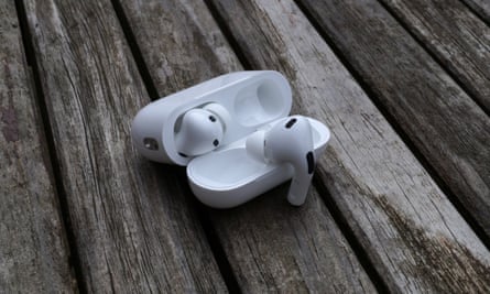 Etui AirPods Pro 2 otwarte na stole z jedną słuchawką wiszącą na pokrywie.