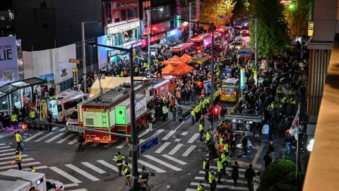 Widzowie, policja i ratownicy medyczni gromadzą się w popularnej dzielnicy nocnego życia Itaewon w Seulu 30 października 2022 roku.