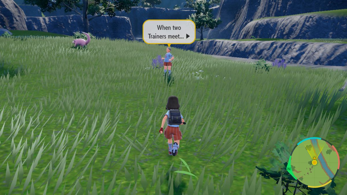 Trener Pokémonów biegnie w kierunku innego trenera na trawiastym polu