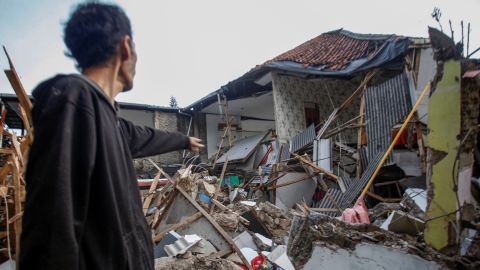 Mężczyzna stoi w pobliżu domów uszkodzonych po trzęsieniu ziemi, które nawiedziło Cianjur, prowincja Jawa Zachodnia, Indonezja, 21 listopada 2022 r.