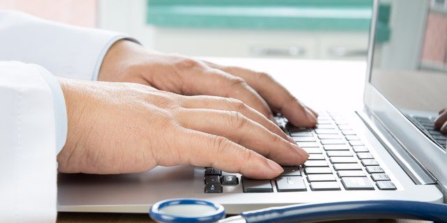 Zbliżenie dłoni lekarza piszącej na komputerze